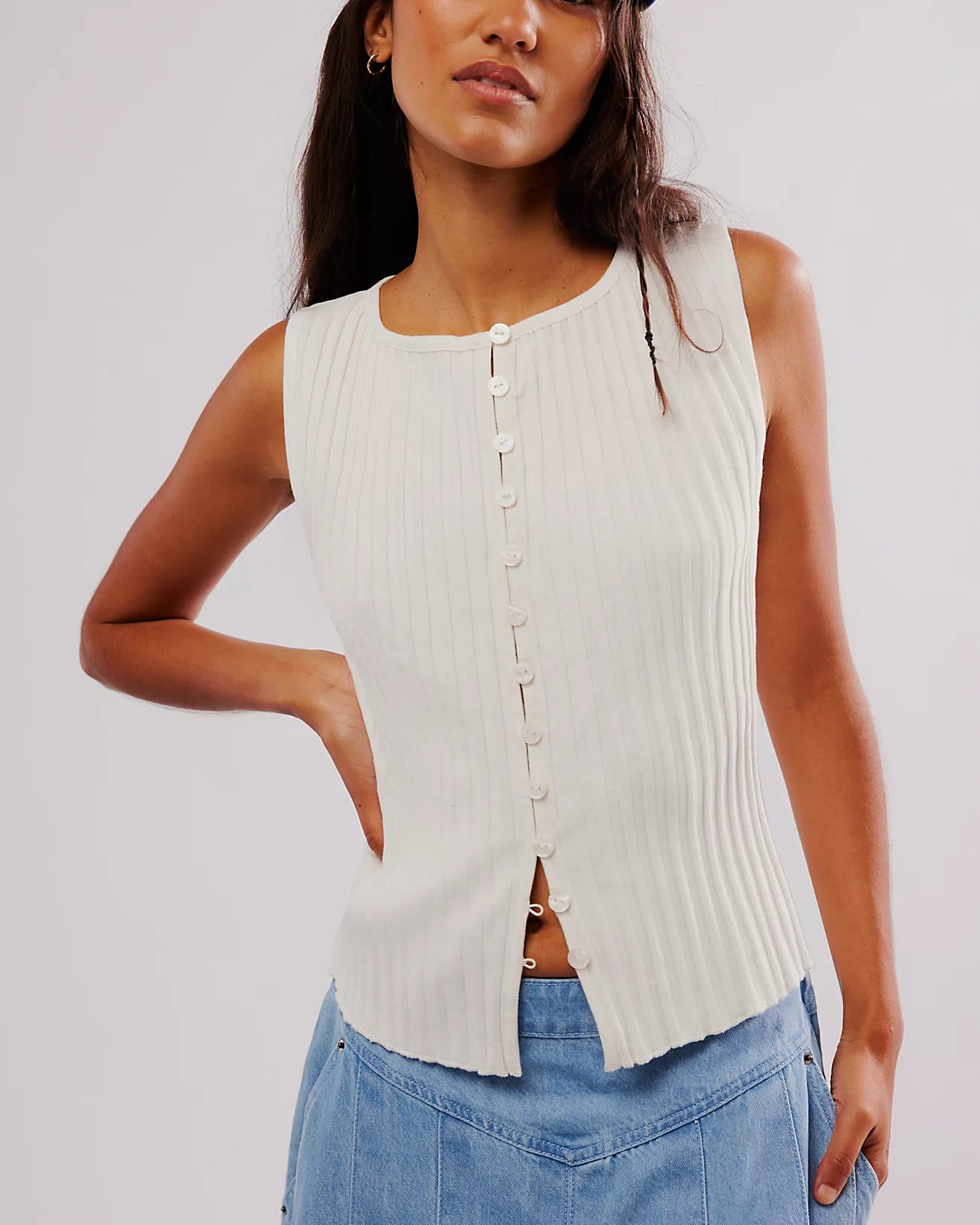 Free People Tilly Vest made from a soft, textured fabric with a relaxed, sleeveless design. This button-front vest offers a stylish and lightweight layering piece, perfect for adding a chic touch to any outfit, Ivory