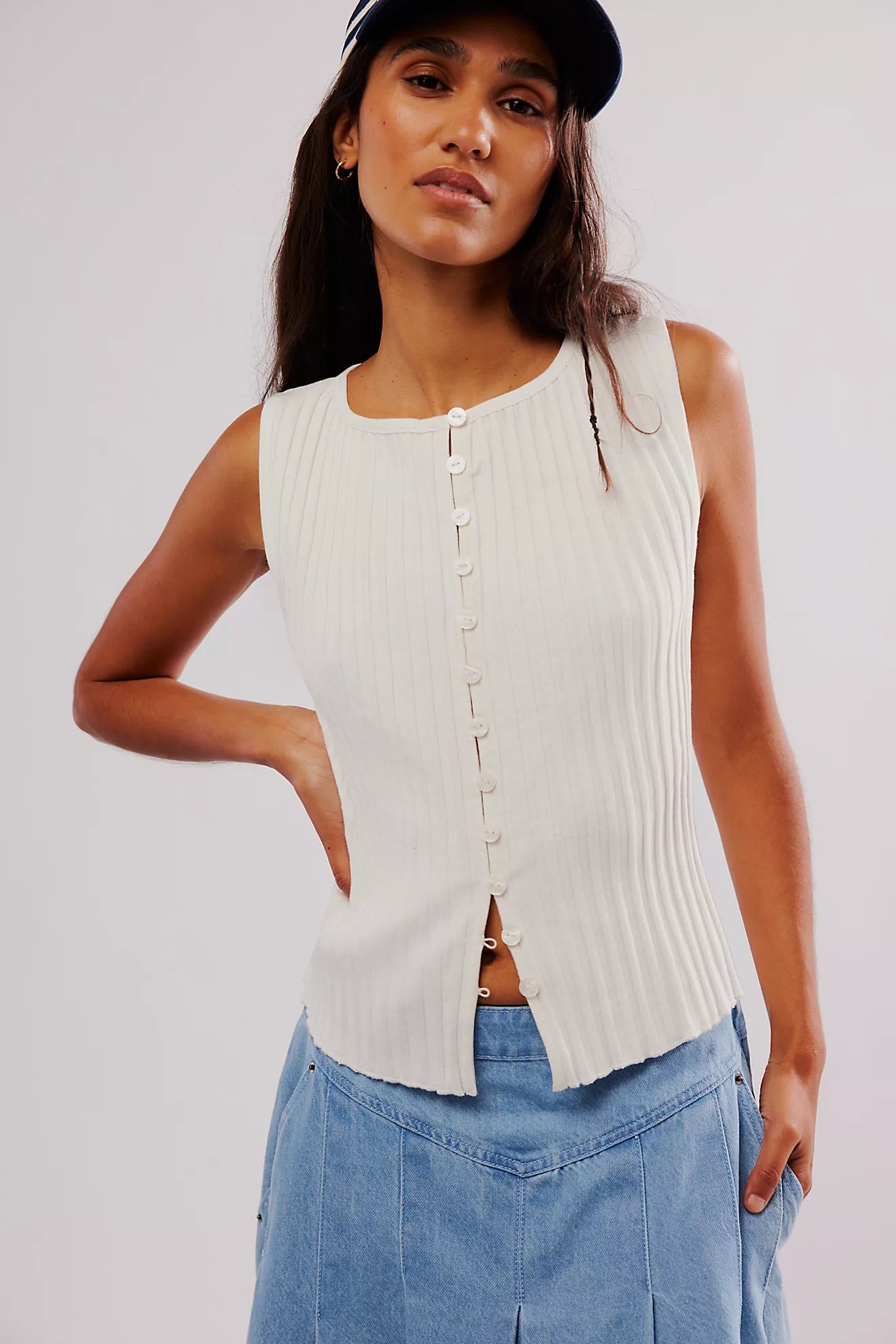 Free People Tilly Vest made from a soft, textured fabric with a relaxed, sleeveless design. This button-front vest offers a stylish and lightweight layering piece, perfect for adding a chic touch to any outfit, Ivory