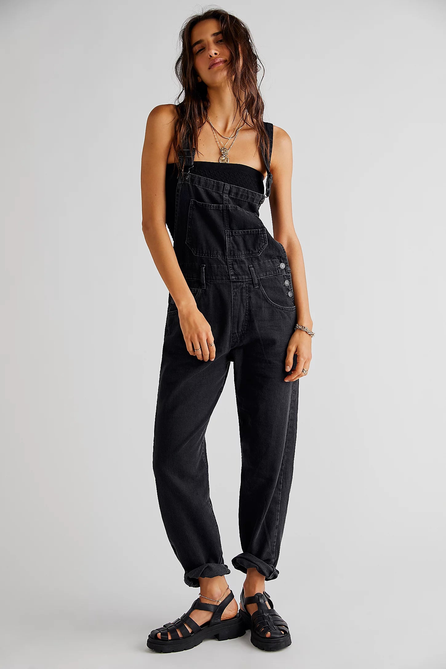 We The Free Ziggy Denim Overalls featuring a relaxed, vintage-inspired fit with wide legs and a distressed, worn-in look. The overalls have adjustable shoulder straps, a front bib pocket, and a button-up closure, offering both style and comfort for everyday wear, Mineral Black