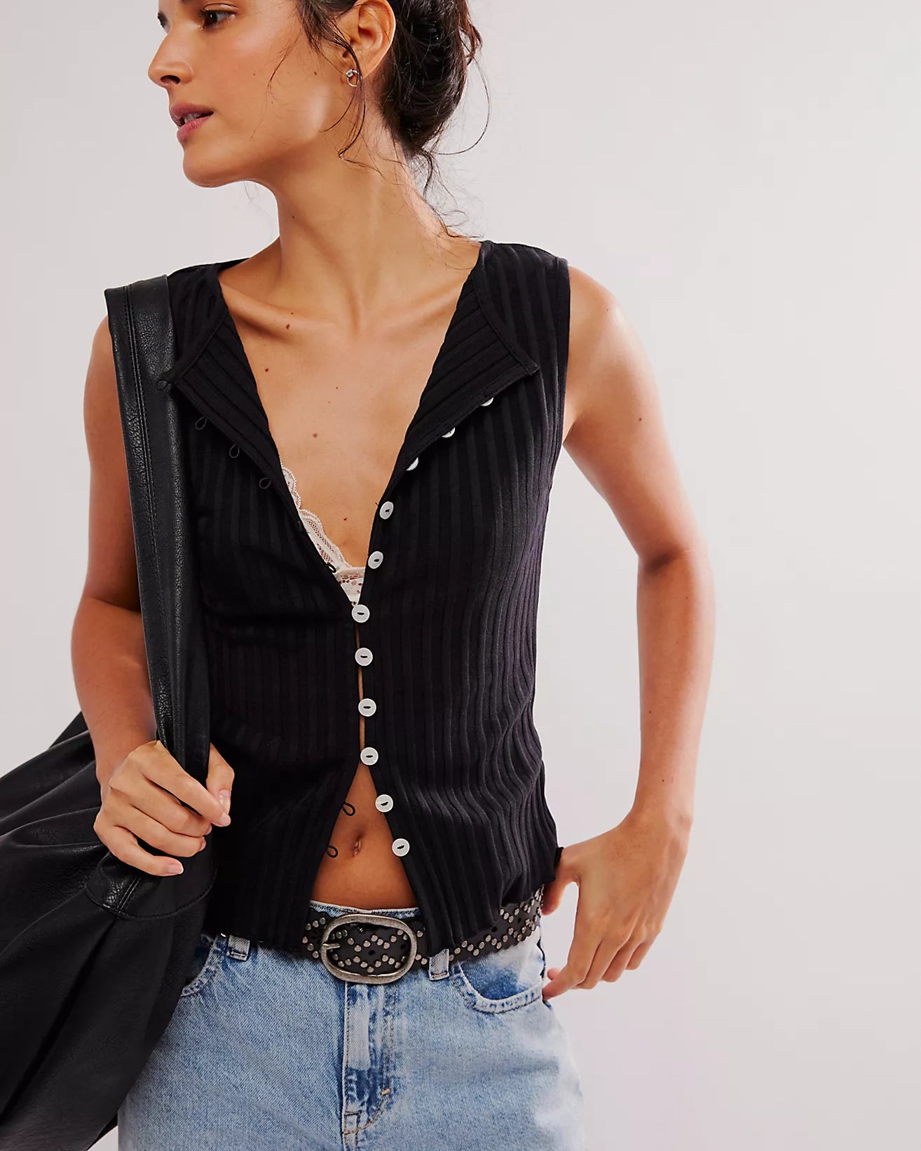 Free People Tilly Vest made from a soft, textured fabric with a relaxed, sleeveless design. This button-front vest offers a stylish and lightweight layering piece, perfect for adding a chic touch to any outfit, Black