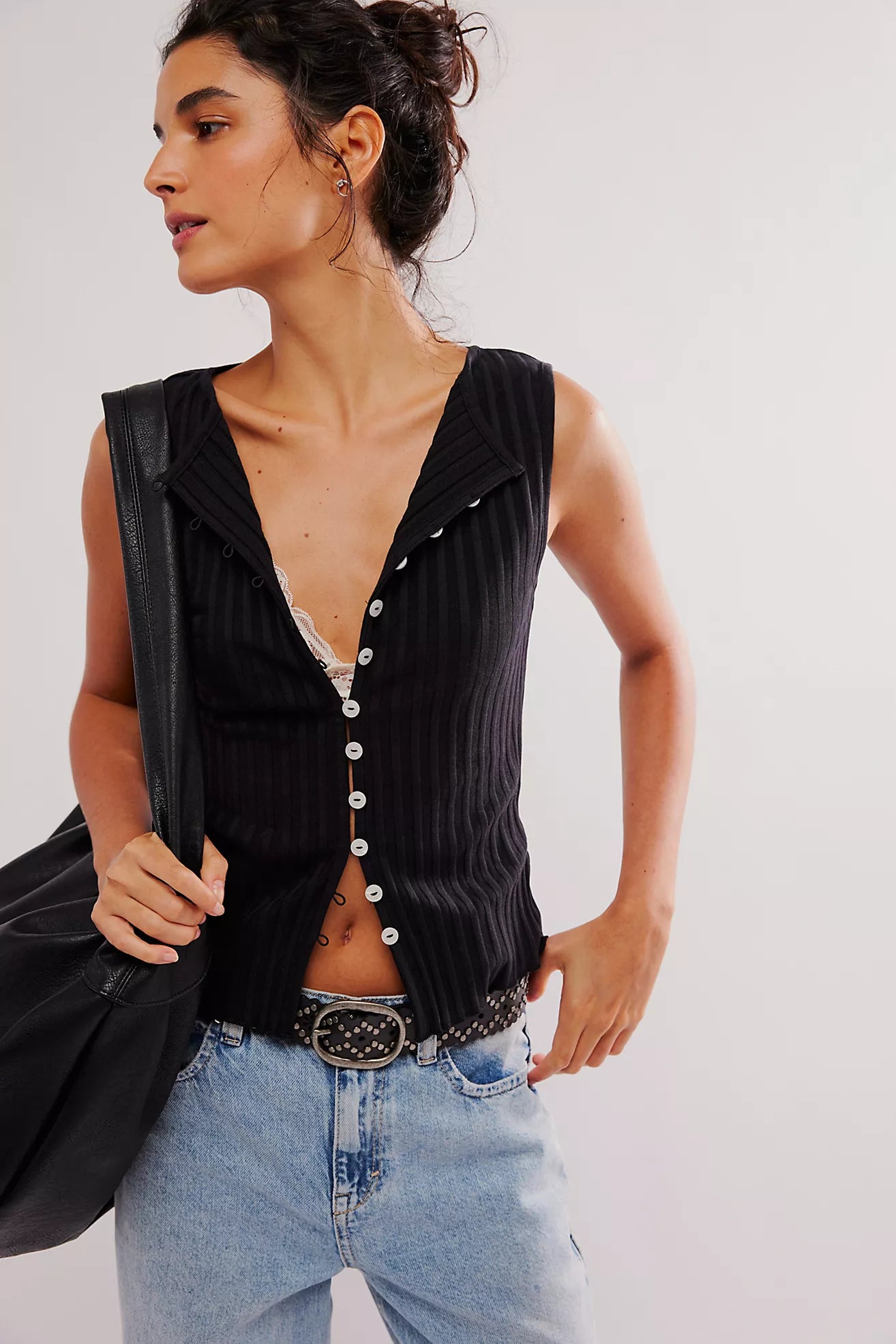 Free People Tilly Vest made from a soft, textured fabric with a relaxed, sleeveless design. This button-front vest offers a stylish and lightweight layering piece, perfect for adding a chic touch to any outfit, Black