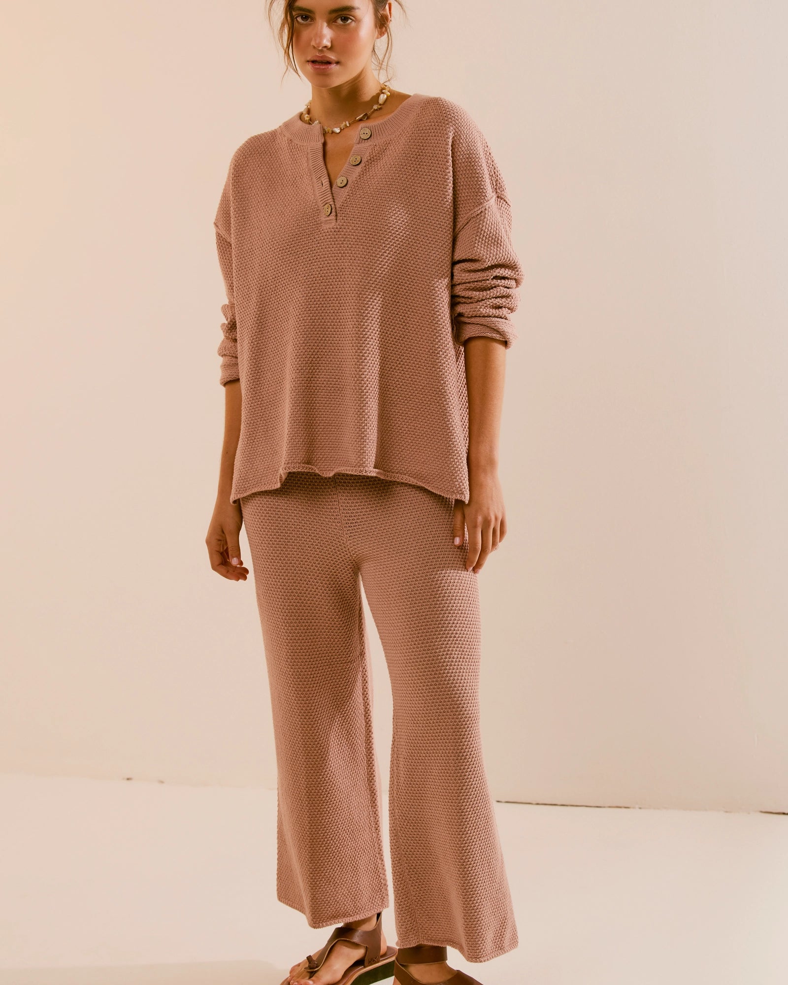 Free People Hailee Sweater Set featuring a soft, ribbed knit long-sleeve sweater and matching high-waisted, wide-leg pants. The relaxed fit of both pieces offers a comfortable and stylish look, perfect for lounging or casual outings, Tuscany