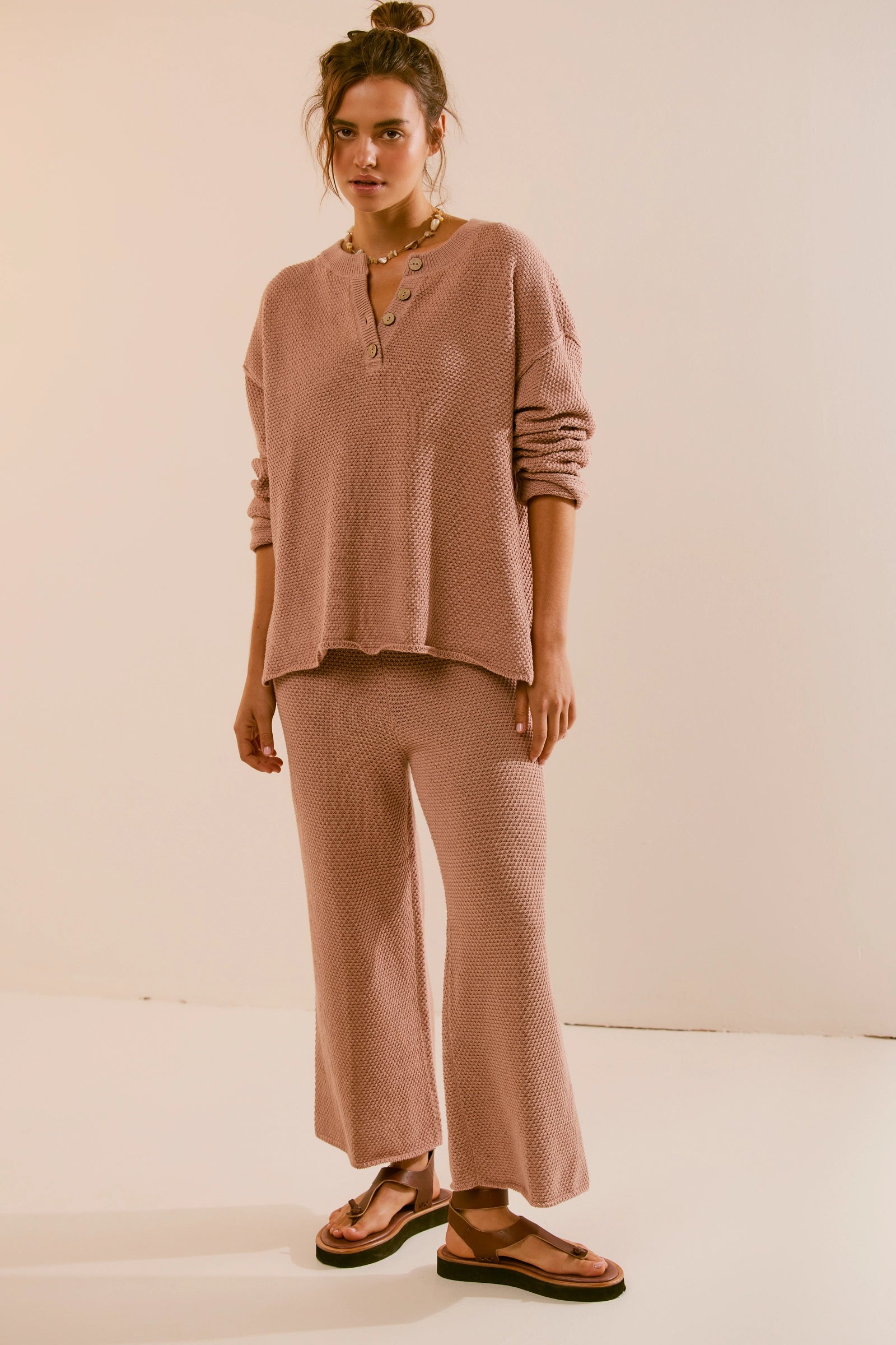 Free People Hailee Sweater Set featuring a soft, ribbed knit long-sleeve sweater and matching high-waisted, wide-leg pants. The relaxed fit of both pieces offers a comfortable and stylish look, perfect for lounging or casual outings, Tuscany