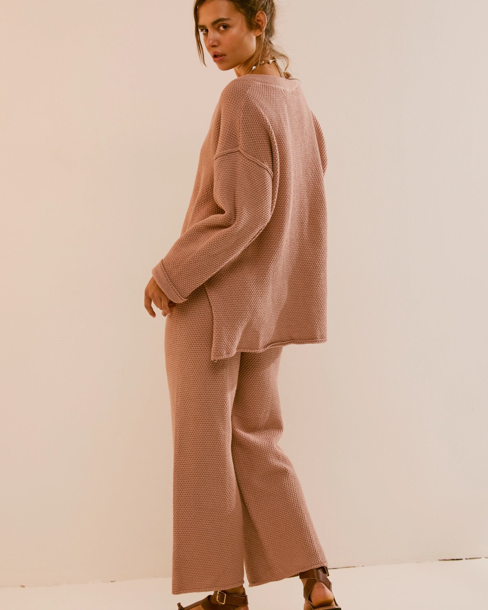 Free People Hailee Sweater Set featuring a soft, ribbed knit long-sleeve sweater and matching high-waisted, wide-leg pants. The relaxed fit of both pieces offers a comfortable and stylish look, perfect for lounging or casual outings, Tuscany