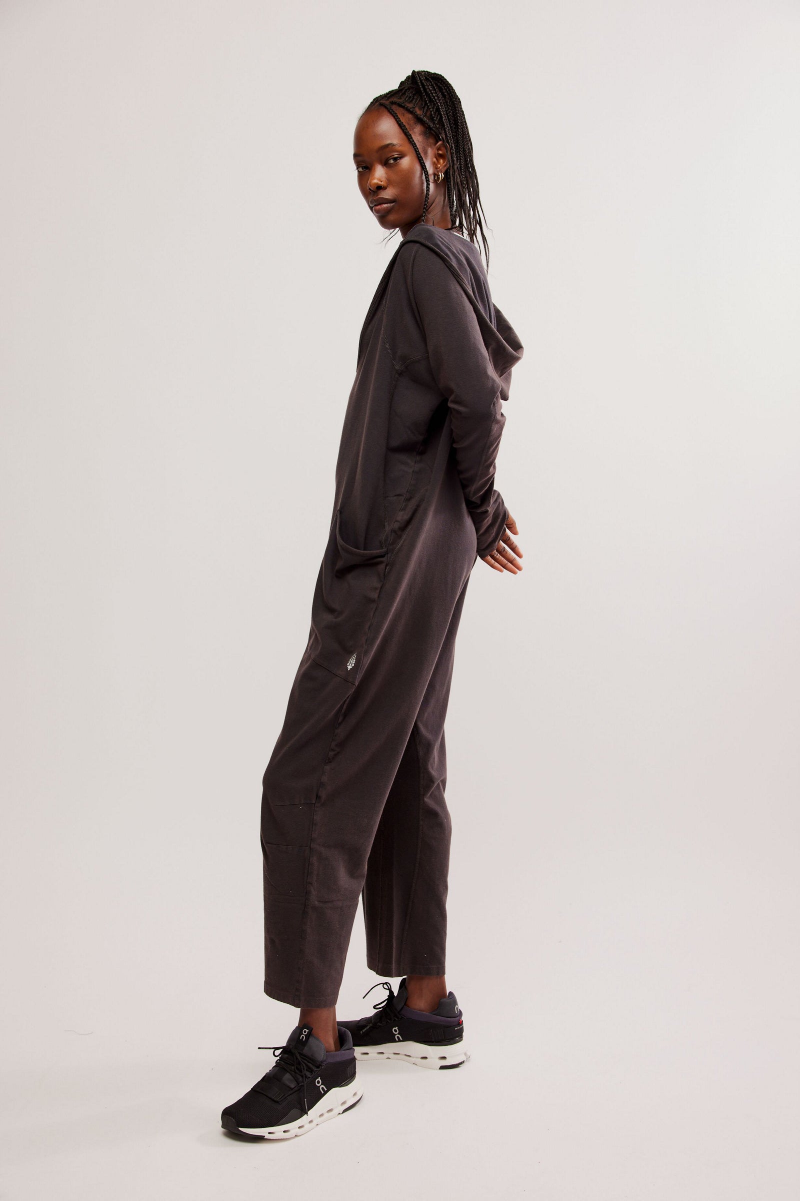 Free People Hot Shot Long Sleeve Onesie made from soft, stretchy fabric with a loose, relaxed design. This one-piece features a scoop neckline and long sleeves, offering a comfortable, laid-back fit that's perfect for layering or wearing on its own, Black