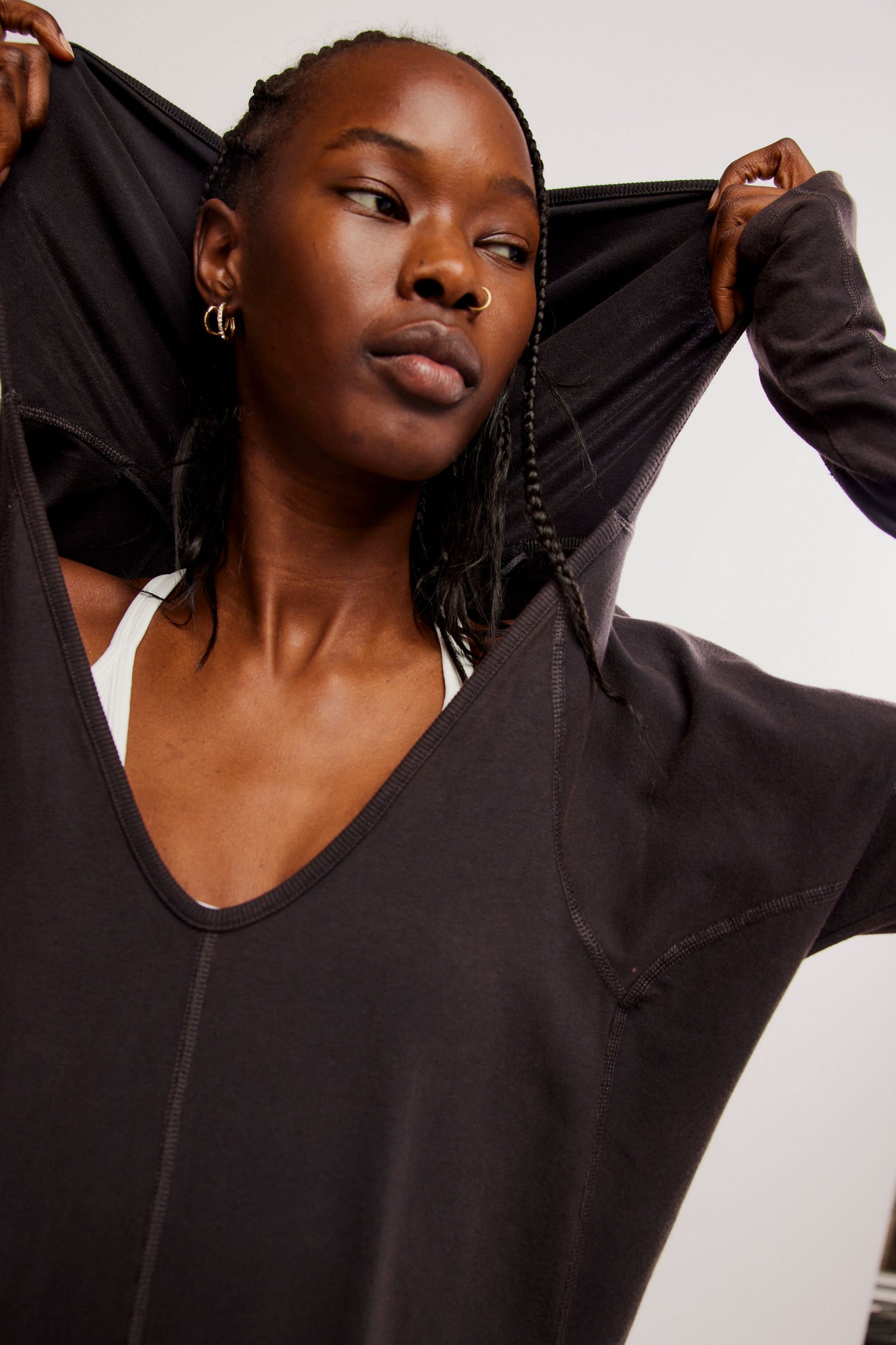 Free People Hot Shot Long Sleeve Onesie made from soft, stretchy fabric with a loose, relaxed design. This one-piece features a scoop neckline and long sleeves, offering a comfortable, laid-back fit that's perfect for layering or wearing on its own, Black