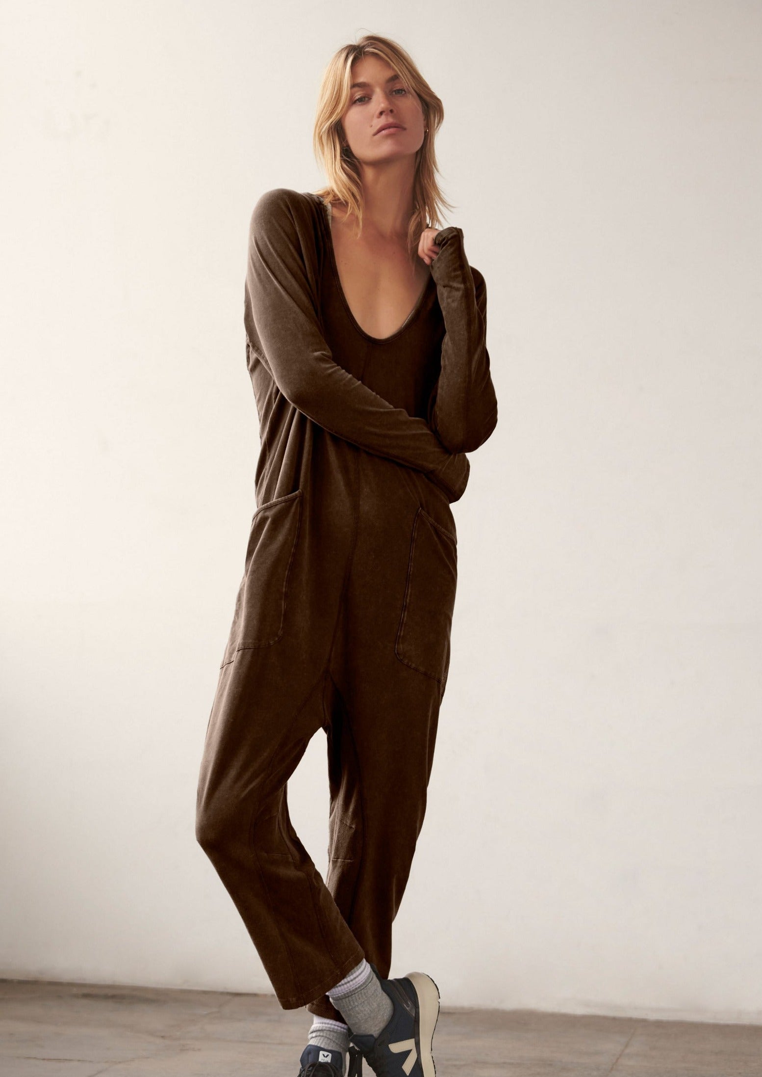 Free People Hot Shot Long Sleeve Onesie made from soft, stretchy fabric with a loose, relaxed design. This one-piece features a scoop neckline and long sleeves, offering a comfortable, laid-back fit that's perfect for layering or wearing on its own, Dark Espresso