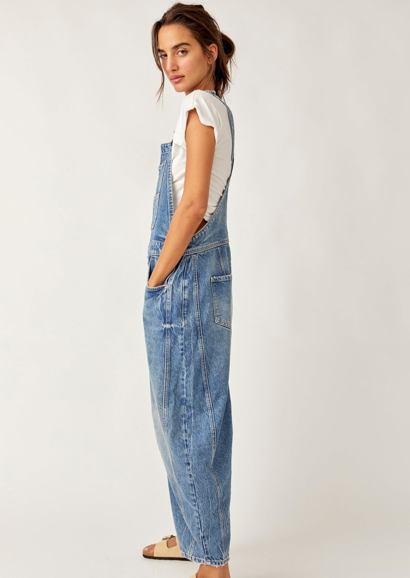 We The Free Good Luck Barrel Overalls with a relaxed, loose-fit design and wide-leg silhouette. These overalls feature adjustable straps and a soft, distressed denim fabric, offering a casual, boho-inspired look with a comfortable, laid-back feel, Ultra Light Beam