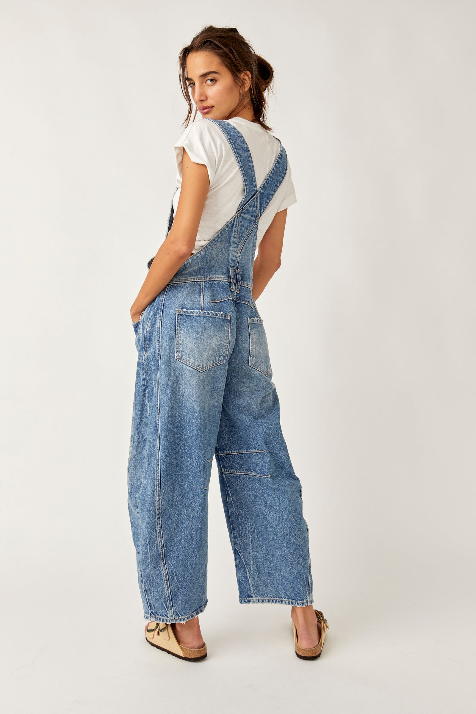 We The Free Good Luck Barrel Overalls with a relaxed, loose-fit design and wide-leg silhouette. These overalls feature adjustable straps and a soft, distressed denim fabric, offering a casual, boho-inspired look with a comfortable, laid-back feel, Ultra Light Beam
