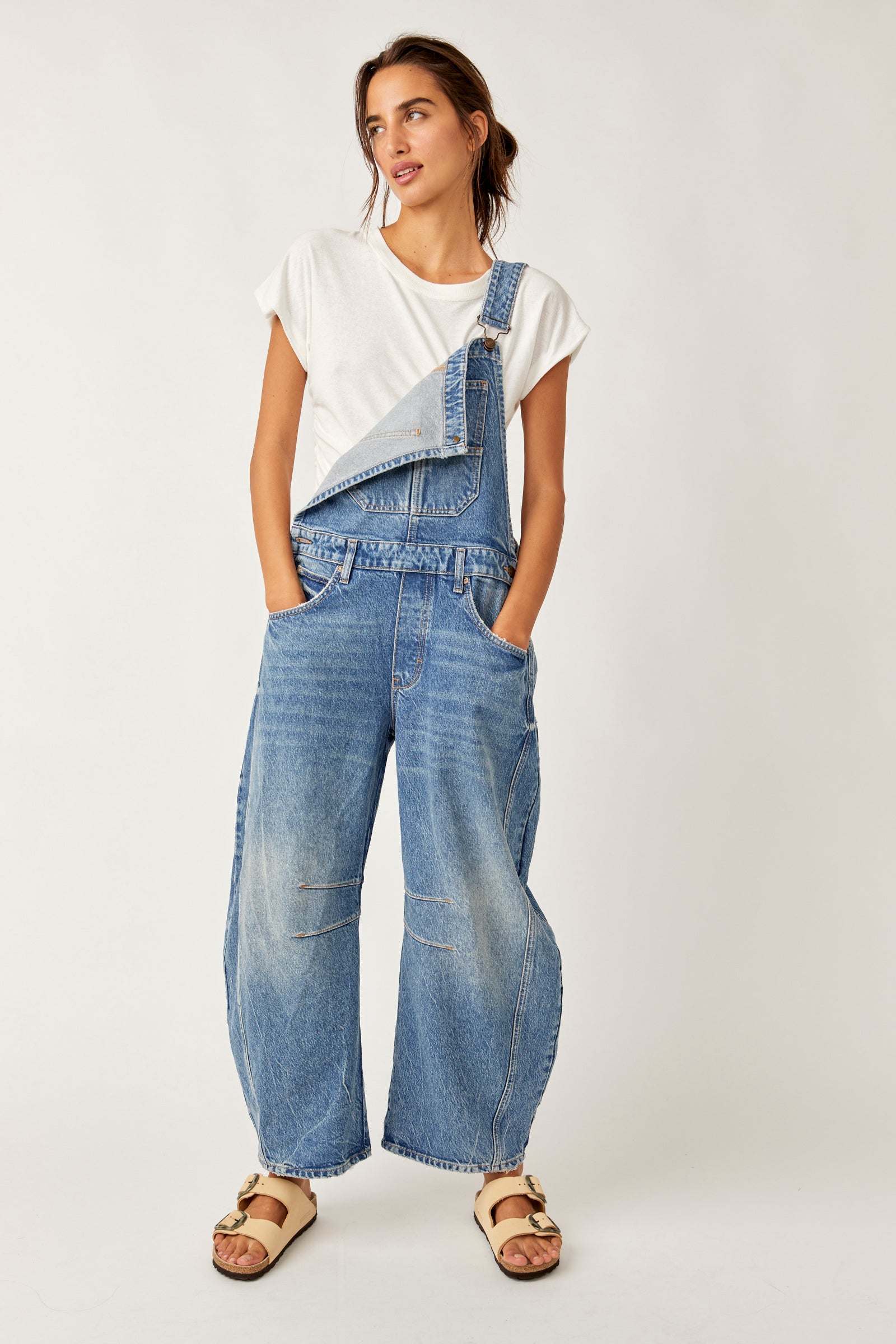 We The Free Good Luck Barrel Overalls with a relaxed, loose-fit design and wide-leg silhouette. These overalls feature adjustable straps and a soft, distressed denim fabric, offering a casual, boho-inspired look with a comfortable, laid-back feel,Ultra Light Beam