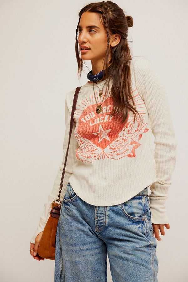 Free People Lucky Locket Tee made from soft, lightweight fabric with a relaxed fit. This short-sleeve tee features a scoop neckline and a unique graphic design with a locket-inspired print, Ivory