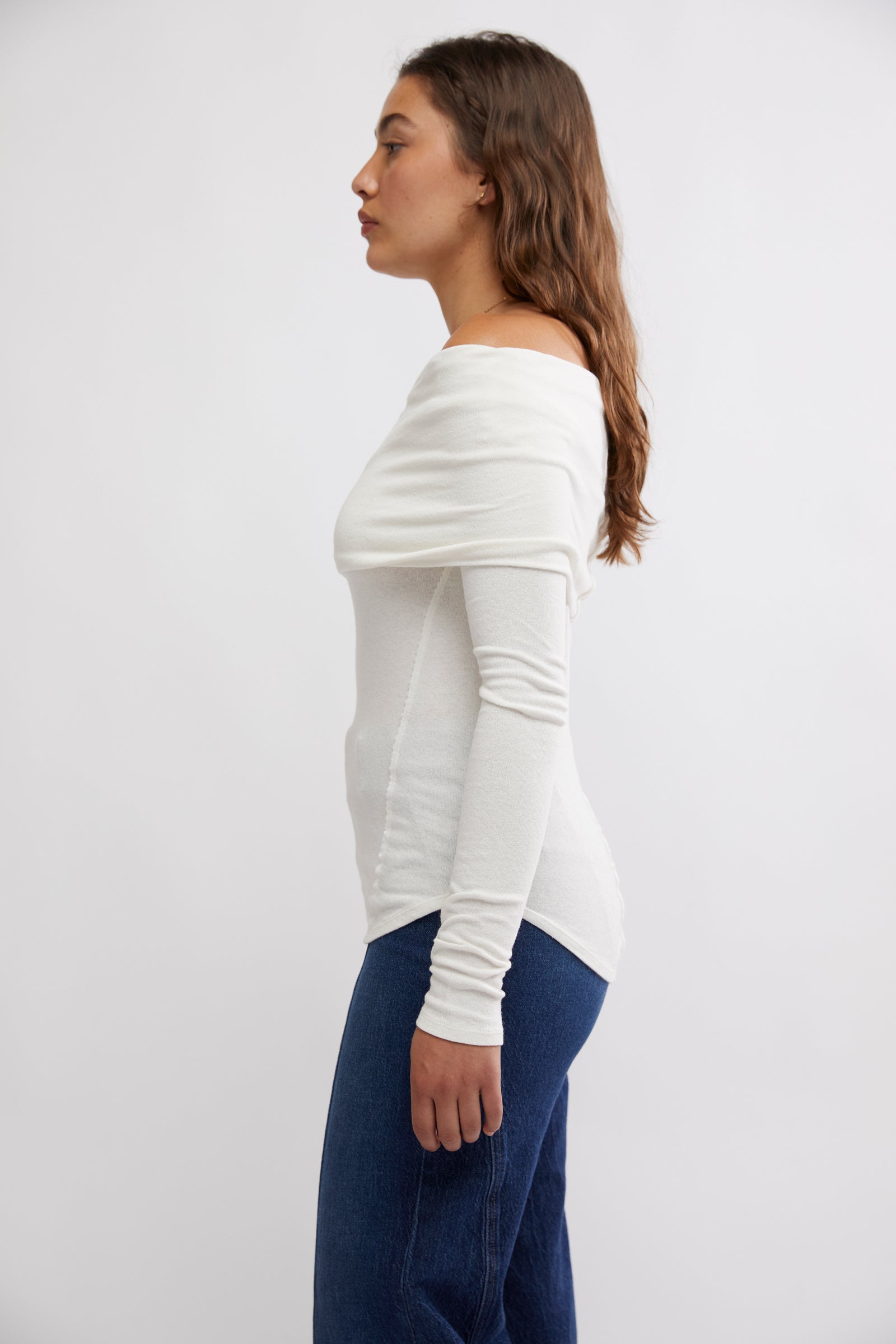 Free People Iris Layering Top made from soft, stretchy fabric with an off-the-shoulder design. This fitted long-sleeve top offers a sleek, minimalistic look, perfect for layering under jackets or sweaters for a cozy yet stylish feel, White