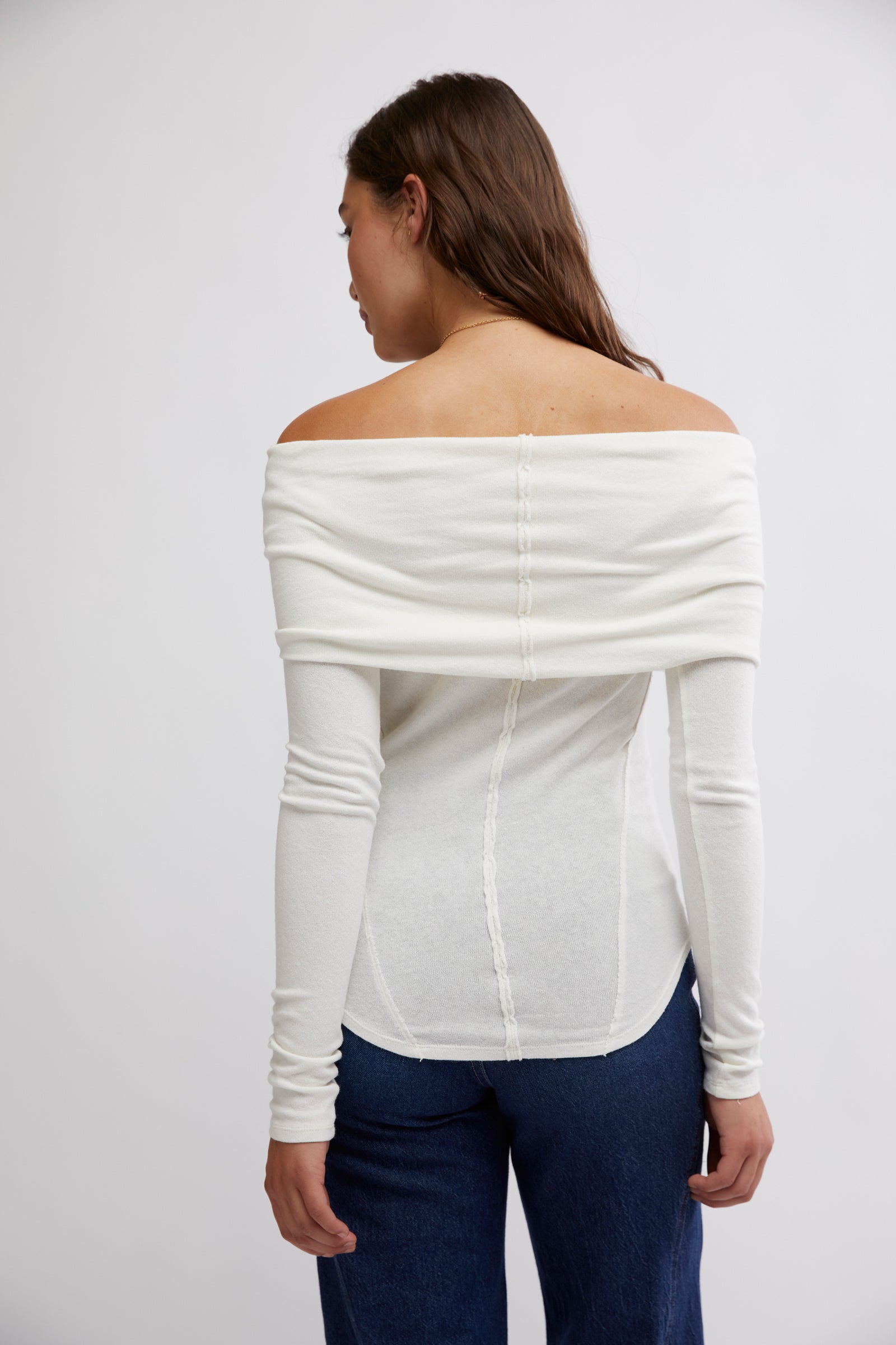 Free People Iris Layering Top made from soft, stretchy fabric with an off-the-shoulder design. This fitted long-sleeve top offers a sleek, minimalistic look, perfect for layering under jackets or sweaters for a cozy yet stylish feel, White