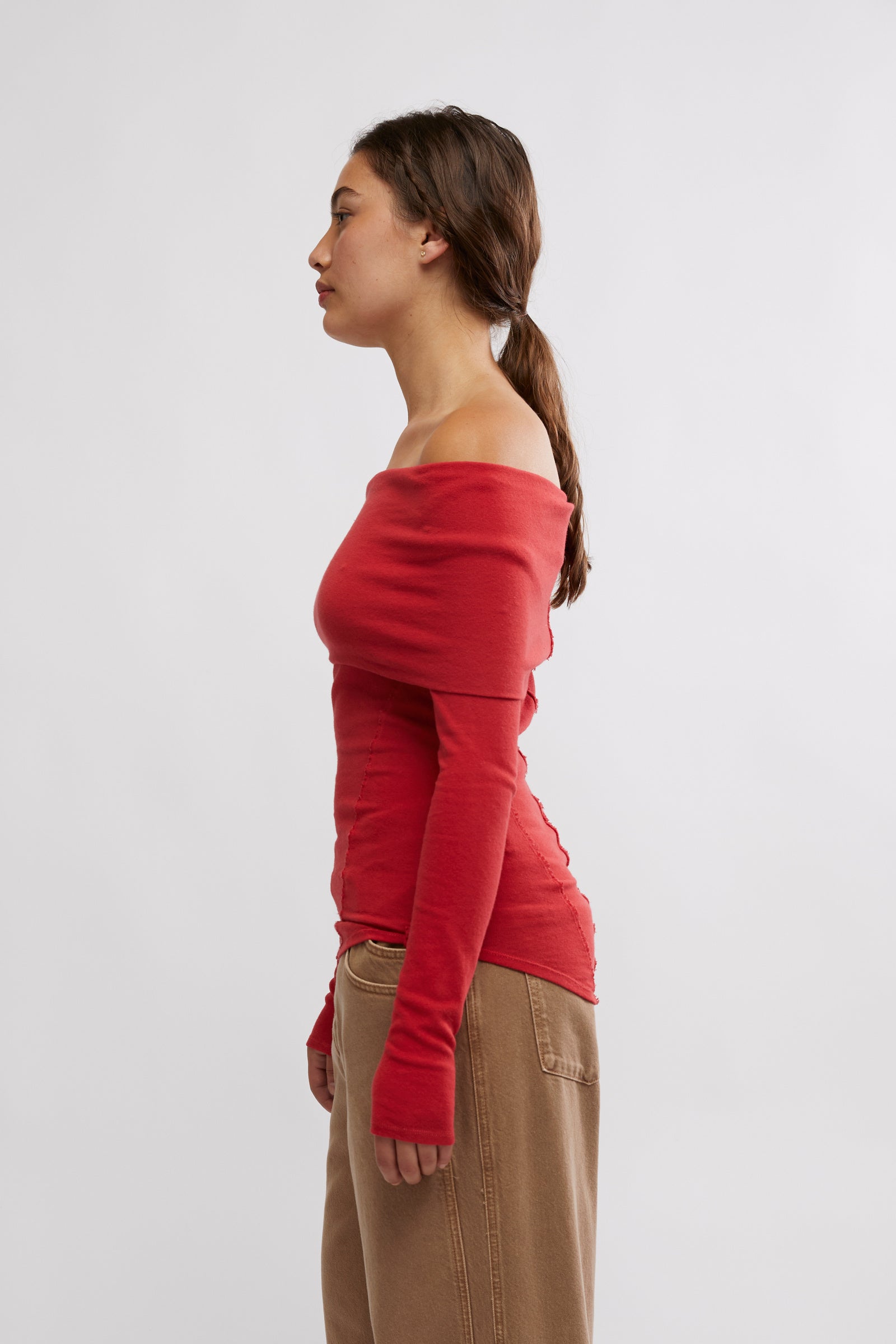 Free People Iris Layering Top made from soft, stretchy fabric with an off-the-shoulder design. This fitted long-sleeve top offers a sleek, minimalistic look, perfect for layering under jackets or sweaters for a cozy yet stylish feel