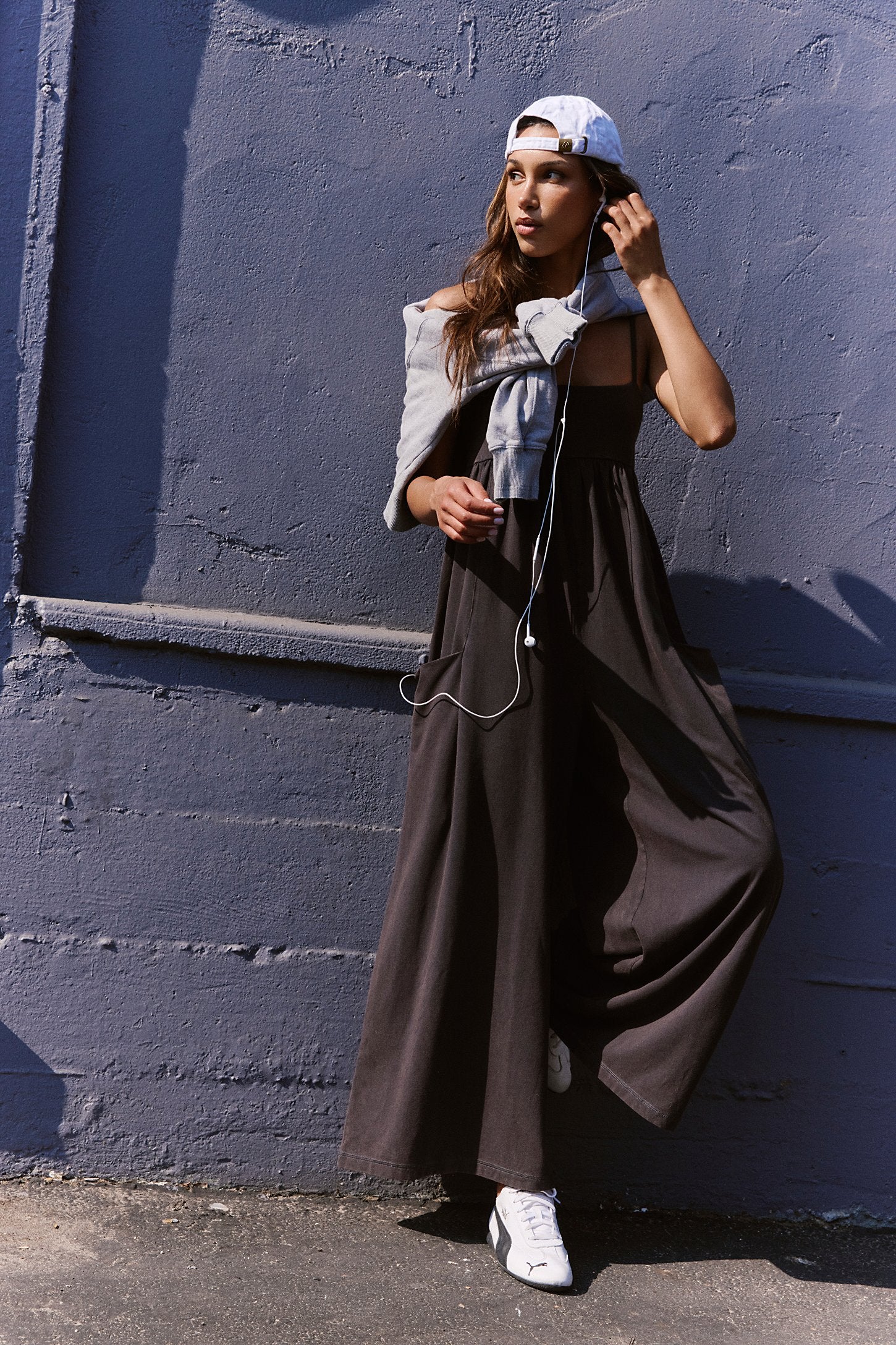 Free People Hot Shot Strappy Onesie, featuring soft cotton-blend fabric, simple shoulder straps, empire waist, and wide-leg slouchy fit, Black