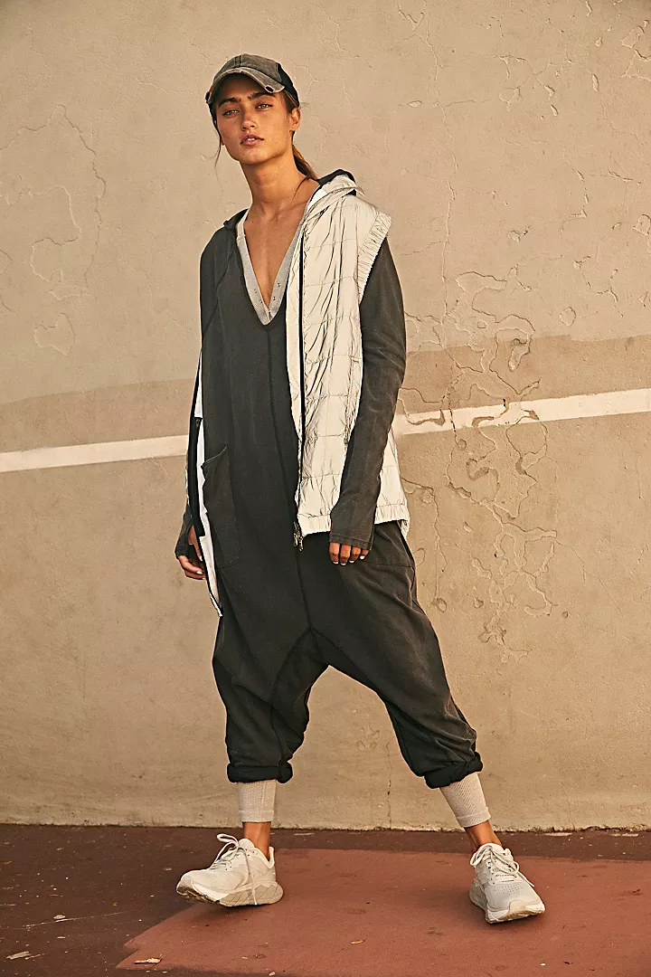 Free People Hot Shot Long Sleeve Onesie made from soft, stretchy fabric with a loose, relaxed design. This one-piece features a scoop neckline and long sleeves, offering a comfortable, laid-back fit that's perfect for layering or wearing on its own, Black