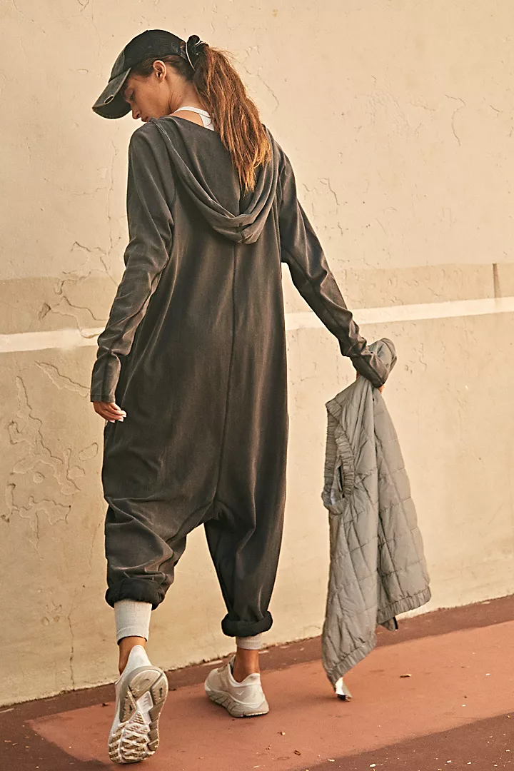 Free People Hot Shot Long Sleeve Onesie made from soft, stretchy fabric with a loose, relaxed design. This one-piece features a scoop neckline and long sleeves, offering a comfortable, laid-back fit that's perfect for layering or wearing on its own, Black
