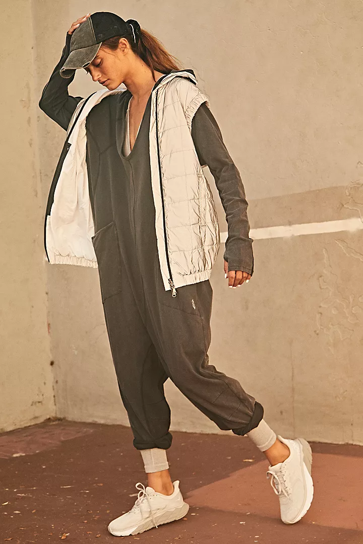 Free People Hot Shot Long Sleeve Onesie made from soft, stretchy fabric with a loose, relaxed design. This one-piece features a scoop neckline and long sleeves, offering a comfortable, laid-back fit that's perfect for layering or wearing on its own, Black