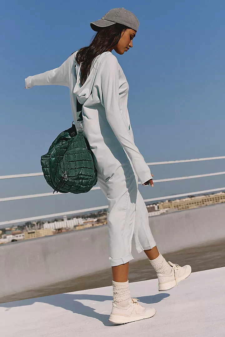 Free People Hot Shot Long Sleeve Onesie made from soft, stretchy fabric with a loose, relaxed design. This one-piece features a scoop neckline and long sleeves, offering a comfortable, laid-back fit that's perfect for layering or wearing on its own, Arctic Snow