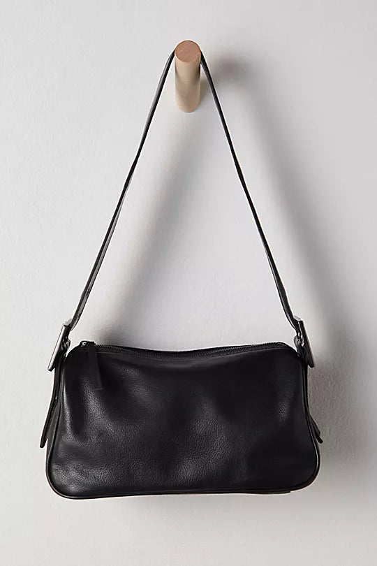 Free People Arm Candy Bag in luxe leather with a thick adjustable strap, rivet detailing, and a zip-top closure, Black