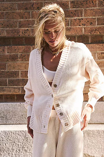 Free People Hailee Cardi Set featuring a soft, knit fabric with a relaxed fit. The set includes a long-sleeve, open-front cardigan and matching knit pants, offering a cozy and stylish look, perfect for casual wear or lounging, Powder Sand