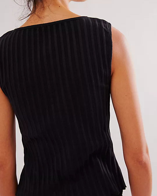 Free People Tilly Vest made from a soft, textured fabric with a relaxed, sleeveless design. This button-front vest offers a stylish and lightweight layering piece, perfect for adding a chic touch to any outfit, Black