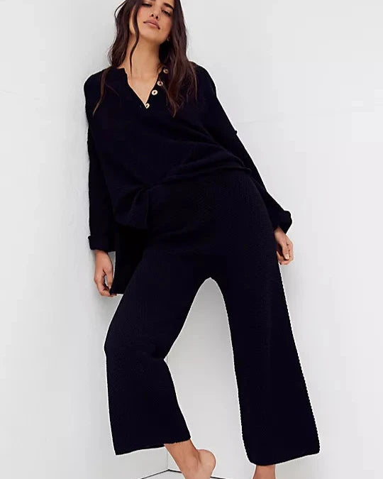 Free People Hailee Sweater Set featuring a soft, ribbed knit long-sleeve sweater and matching high-waisted, wide-leg pants. The relaxed fit of both pieces offers a comfortable and stylish look, perfect for lounging or casual outings, Black