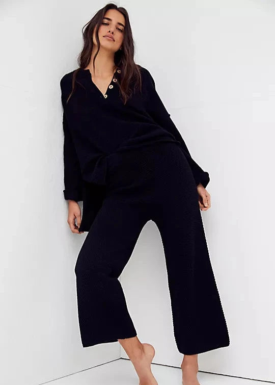 Free People Hailee Sweater Set featuring a soft, ribbed knit long-sleeve sweater and matching high-waisted, wide-leg pants. The relaxed fit of both pieces offers a comfortable and stylish look, perfect for lounging or casual outings, Black
