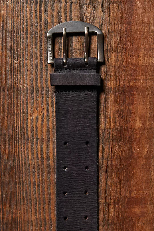 We The Free Double Cross Belt made from distressed leather with a bold, double-cross buckle design. This adjustable belt adds a rustic, boho-inspired touch to any outfit, perfect for pairing with jeans or dresses, Black