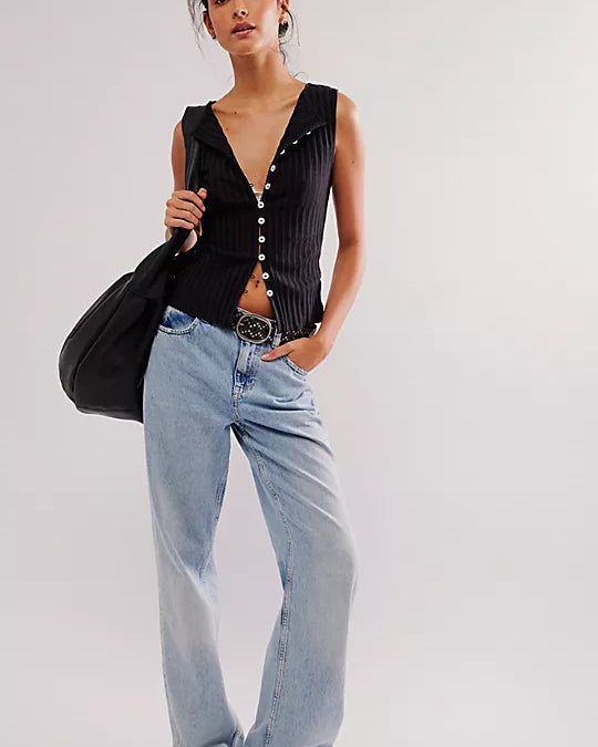 Free People Tilly Vest made from a soft, textured fabric with a relaxed, sleeveless design. This button-front vest offers a stylish and lightweight layering piece, perfect for adding a chic touch to any outfit, Black
