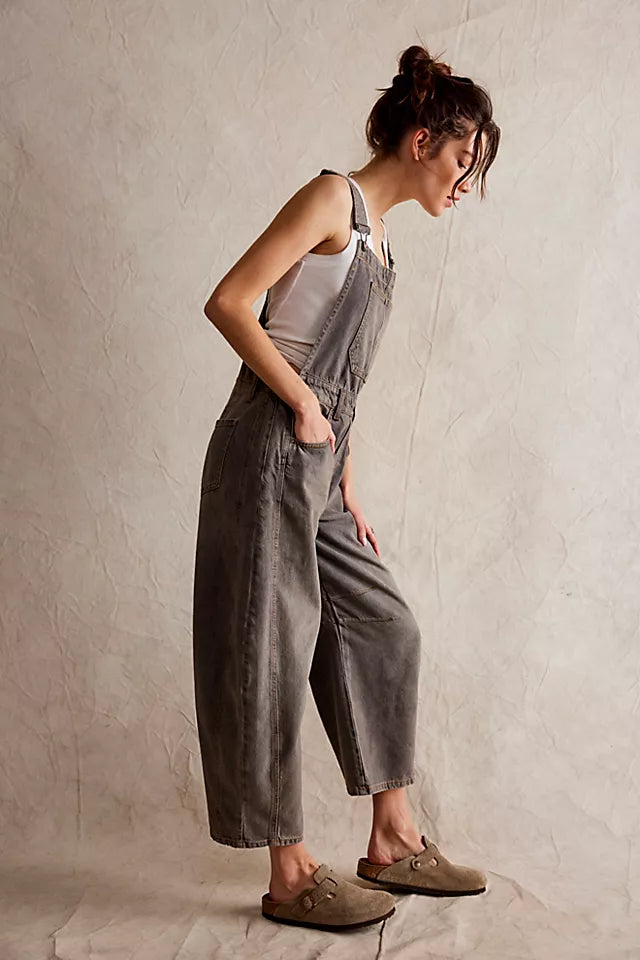 We The Free Good Luck Barrel Overalls with a relaxed, loose-fit design and wide-leg silhouette. These overalls feature adjustable straps and a soft, distressed denim fabric, offering a casual, boho-inspired look with a comfortable, laid-back feel, Archive Grey
