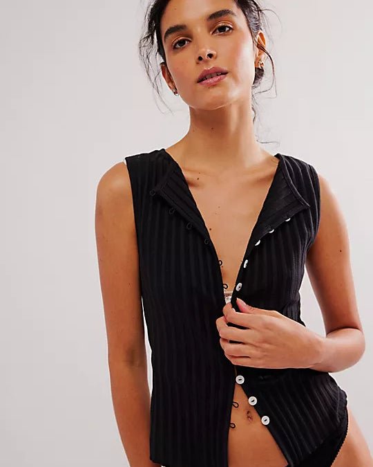 Free People Tilly Vest made from a soft, textured fabric with a relaxed, sleeveless design. This button-front vest offers a stylish and lightweight layering piece, perfect for adding a chic touch to any outfit, Black