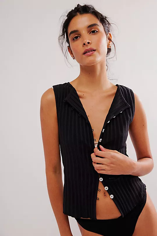 Free People Tilly Vest made from a soft, textured fabric with a relaxed, sleeveless design. This button-front vest offers a stylish and lightweight layering piece, perfect for adding a chic touch to any outfit, Black