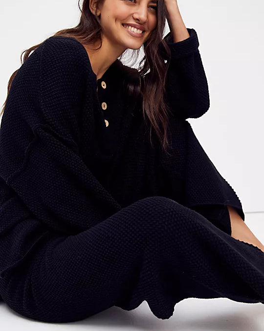 Free People Hailee Sweater Set featuring a soft, ribbed knit long-sleeve sweater and matching high-waisted, wide-leg pants. The relaxed fit of both pieces offers a comfortable and stylish look, perfect for lounging or casual outings, Black
