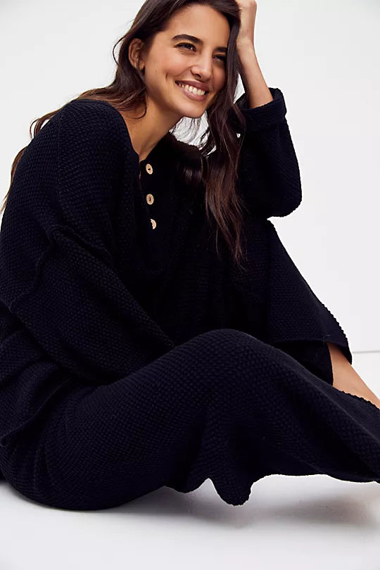 Free People Hailee Sweater Set featuring a soft, ribbed knit long-sleeve sweater and matching high-waisted, wide-leg pants. The relaxed fit of both pieces offers a comfortable and stylish look, perfect for lounging or casual outings, Black
