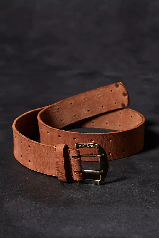 We The Free Double Cross Belt made from distressed leather with a bold, double-cross buckle design. This adjustable belt adds a rustic, boho-inspired touch to any outfit, perfect for pairing with jeans or dresses, Cognac