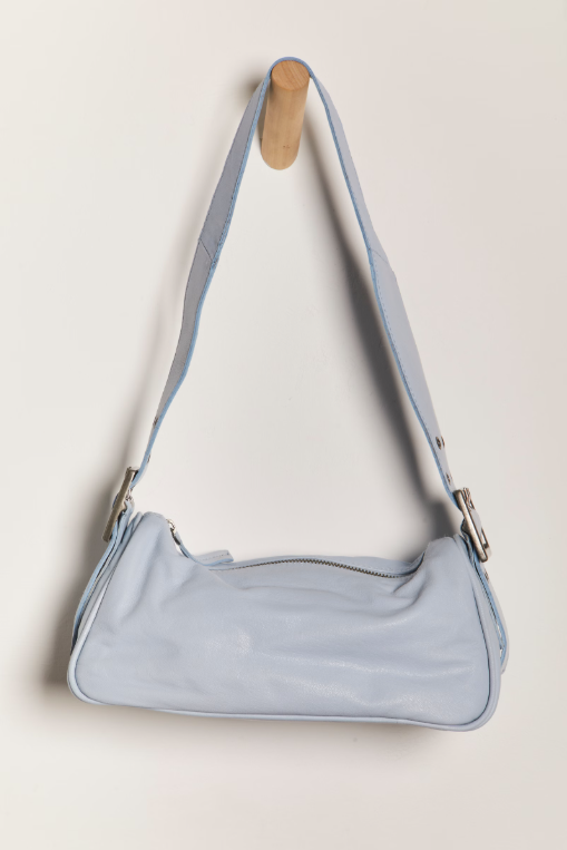 Free People Arm Candy Bag in luxe leather with a thick adjustable strap, rivet detailing, and a zip-top closure, Chambray