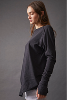 Free People Arden Tee — a slouchy, oversized lightweight long-sleeve tee featuring unfinished trim, thumb holes on the cuffs, and a rounded hem for a relaxed, effortless style, Black