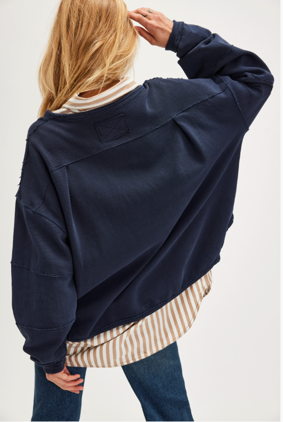 "We The Free Total Eclipse Tee" in an oversized, long-sleeve ribbed cotton fabric. The shirt features a wide scoop neckline, dropped shoulders, and exposed raw seams, Deeper Iris