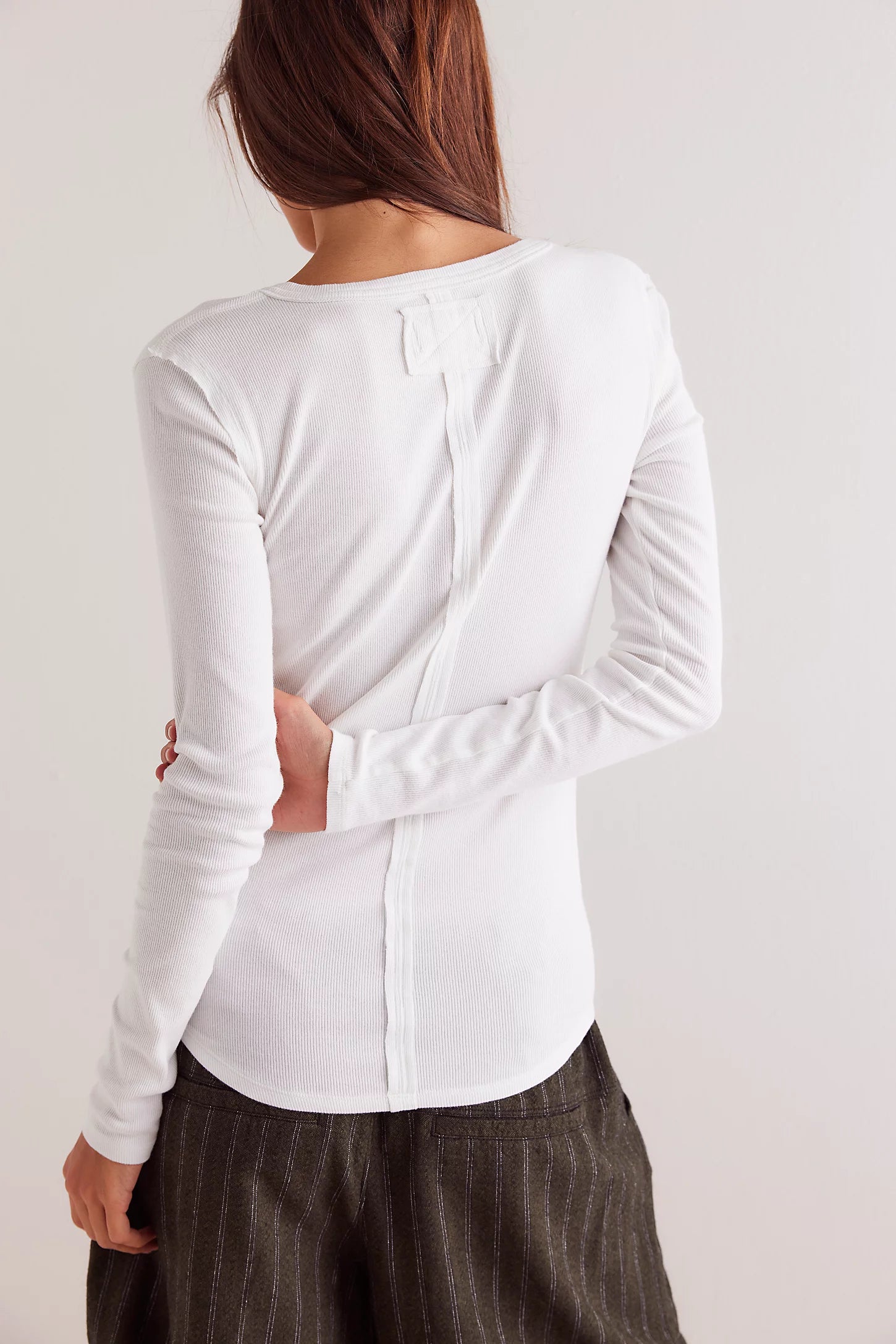 Free People Jamie Henley Top — a fitted, long-sleeve henley-style top featuring soft, stretchy ribbed fabric, a partial button-front closure, scoop neckline, and exposed seam details for a subtly textured, vintage-inspired look, Ivory