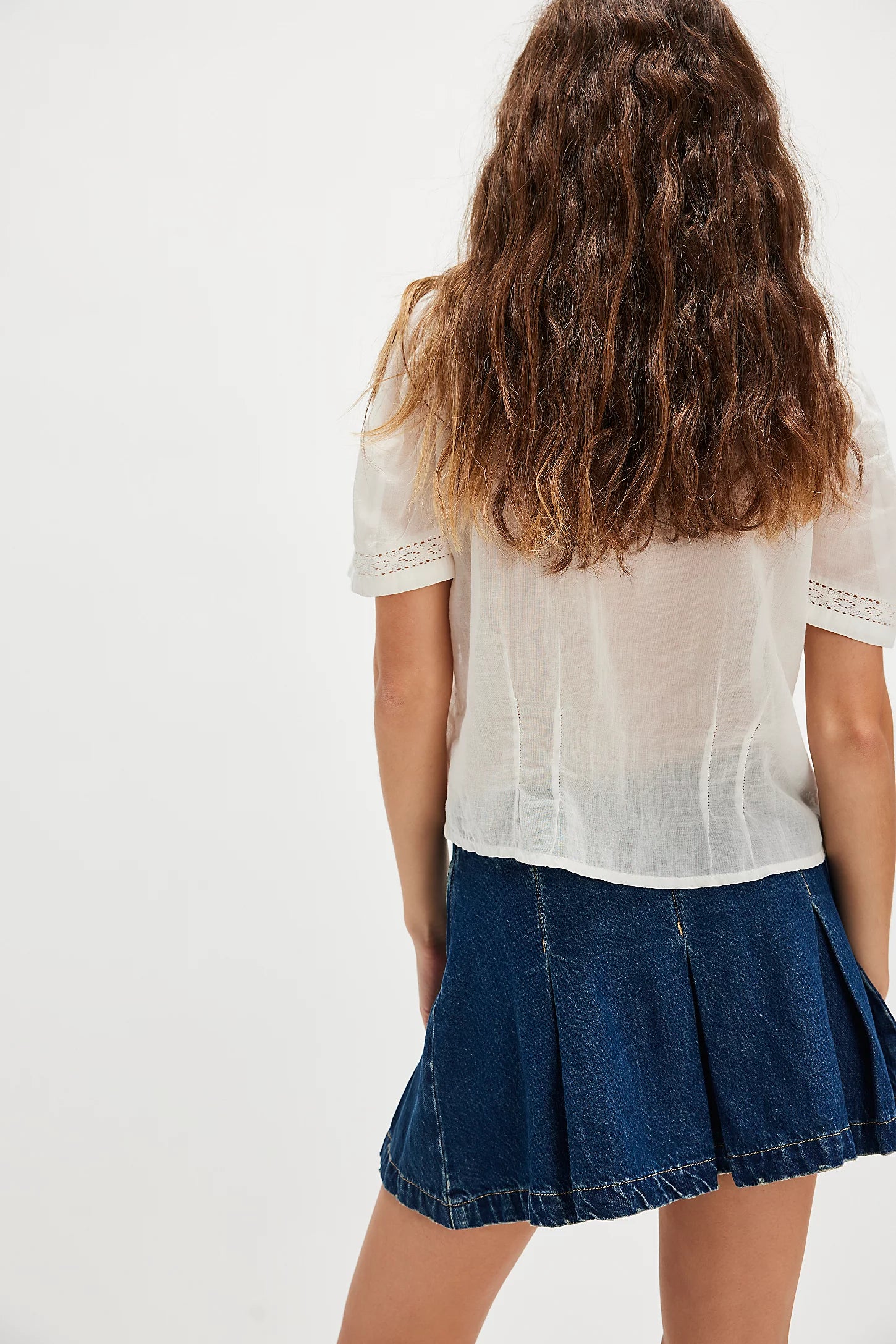 Free People Madison Ave Denim Mini Skirt with mid-rise waist, pleated design, rigid denim fabric, side zip closure, and belt loops, Wandering Eyes