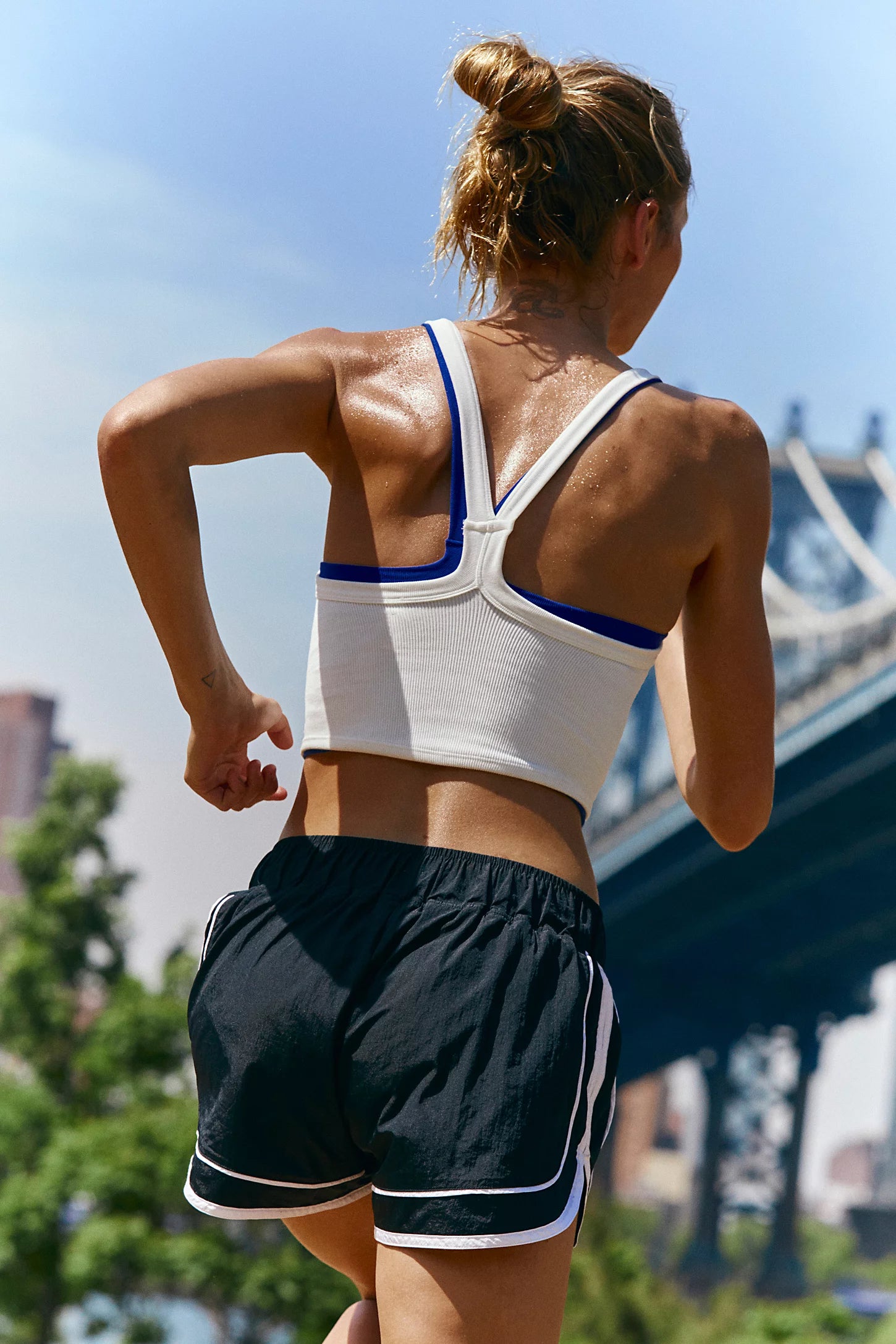 FP Movement "Varsity Blues" shorts in a bold color combo, styled flat: pull-on mid‑rise nylon shorts with contrast side piping and embroidered detailing. A built‑in quick‑dry brief lining is visible at the inner cuff. The fabric has a subtle ripstop texture and slightly crinkled finish, Black Combo