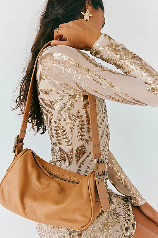 Free People Arm Candy Bag in luxe leather with a thick adjustable strap, rivet detailing, and a zip-top closure, Golden Coast