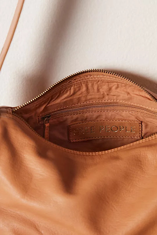 Free People Arm Candy Bag in luxe leather with a thick adjustable strap, rivet detailing, and a zip-top closure, Golden Coast