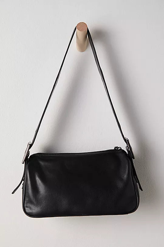 Free People Arm Candy Bag in luxe leather with a thick adjustable strap, rivet detailing, and a zip-top closure, Black