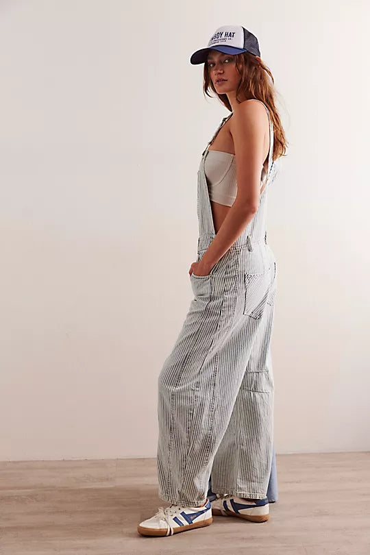 We The Free Good Luck Striped Barrel Overalls featuring a relaxed, cropped fit with a wide-leg silhouette. These overalls are designed with vertical stripes for a playful, vintage-inspired look, adjustable shoulder straps, and a button-front closure for a comfortable and stylish fit, Indigo Railroad